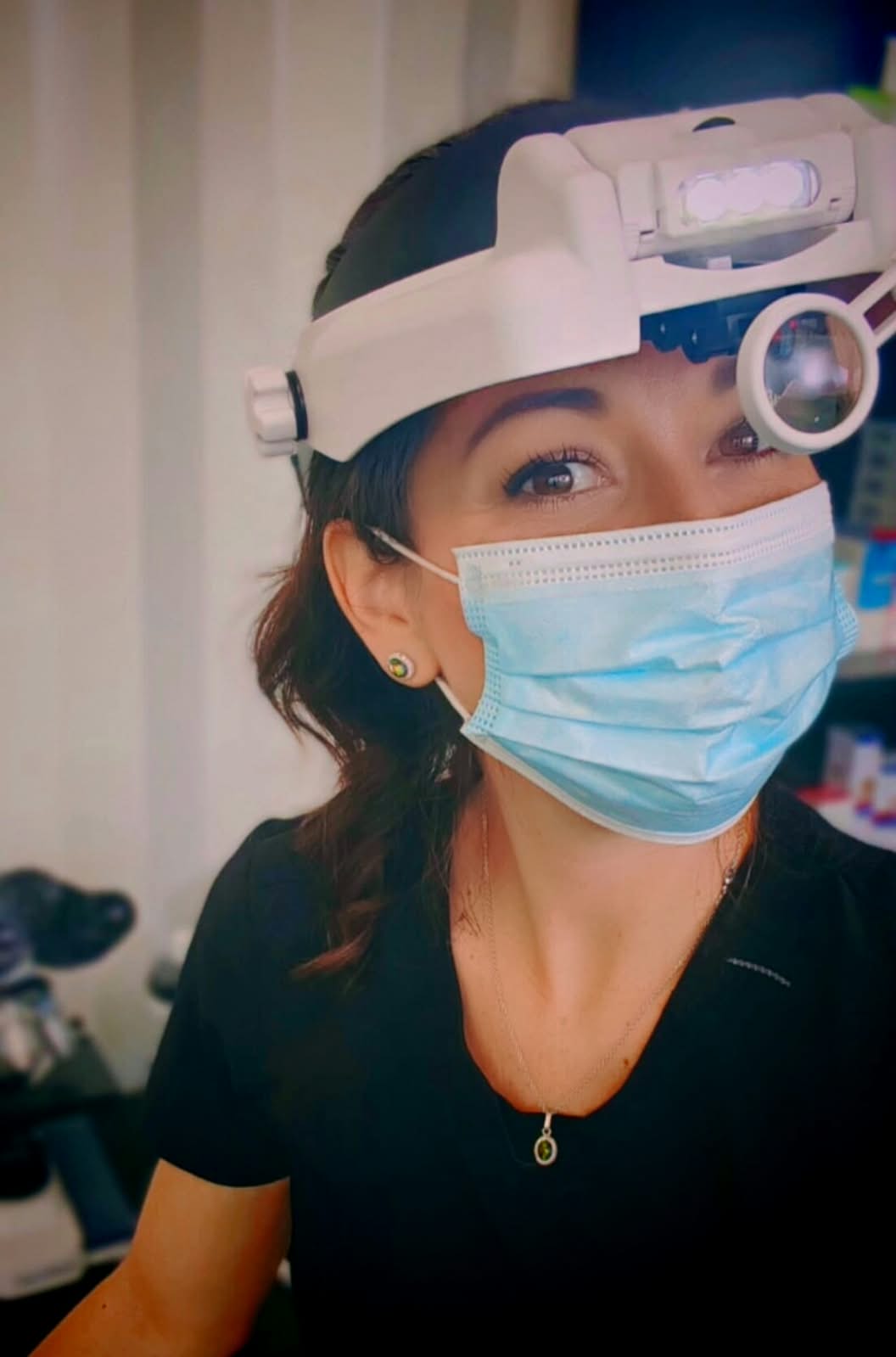 Dr. Sharine wearing surgical loupes and headlight, focused during a clinical procedure